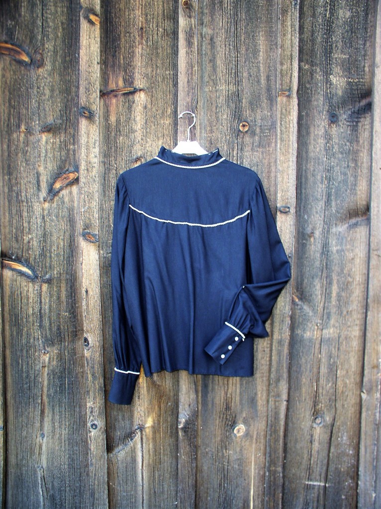 Svart bomullsblus med pärlor vid hals, ok och manschetter knäppning bak