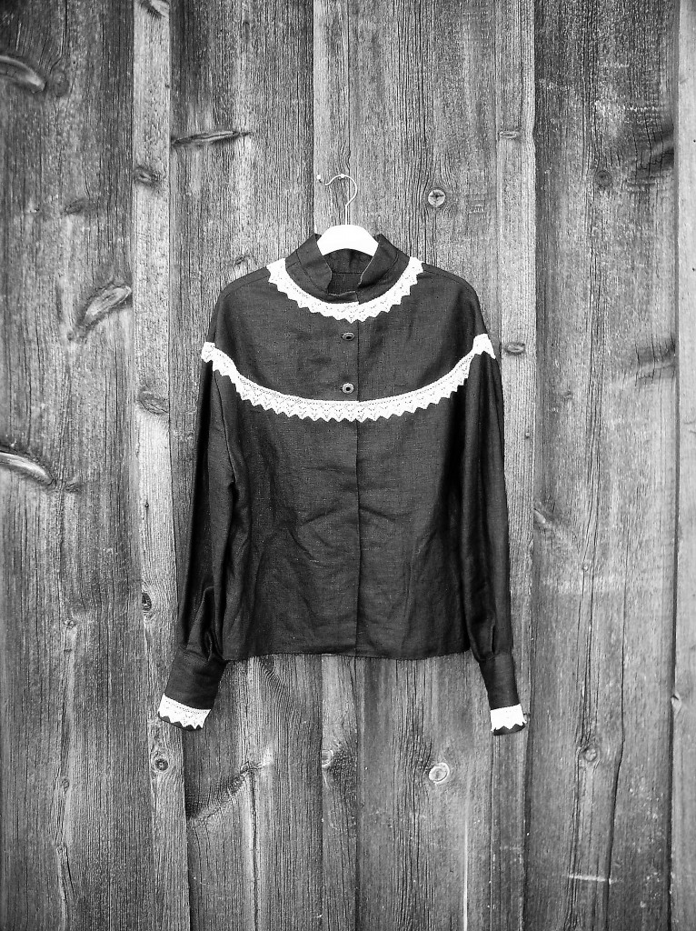 Svart linneblus med spets detaljer knäppt fram